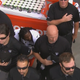 Coaches and staff of the Oakland Raiders gather around running back Marshawn Lynch in an attempt to obscure him as he sits during the national anthem during a game. (@SBNation via Twitter)